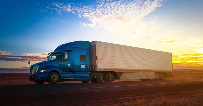blue-semi-truck-highway-sunset-1200x628